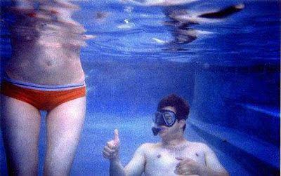 Mann spannert Frau unter Wasser