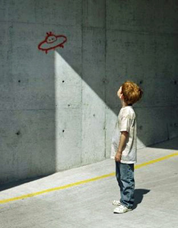Kind sieht lustiges Raumschiff an Wand - Schatten witzig