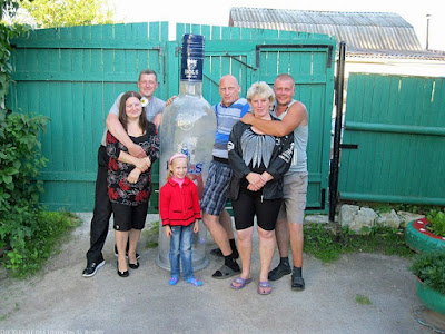 Lustige Familie posiert vor Kamera - Opa mit riesiger Wodka Flasche