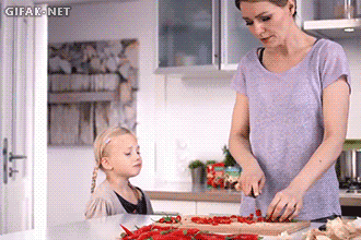 Lustige Hausfrau mit Kind in Küche beim kochen