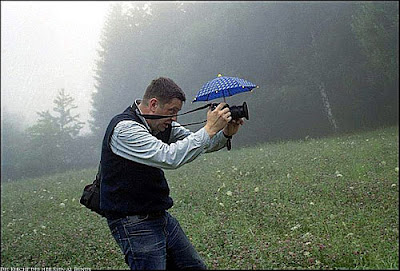 Lustiger Natur Fotograf arbeitet im Regen komische Bilder
