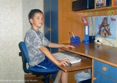 Lustiges dummes Kind sitzt am Computer ohne Bildschirm