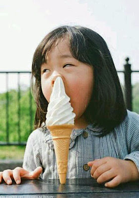 Lustiges Kind beim Eis essen im Sommer witzig