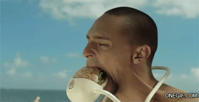 Mann cremt Frau am Strand ein und isst Hamburger lustig