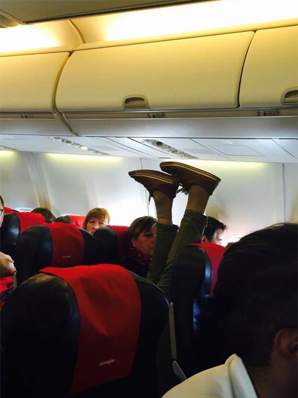 Mann legt im Flugzeug die Füße hoch
