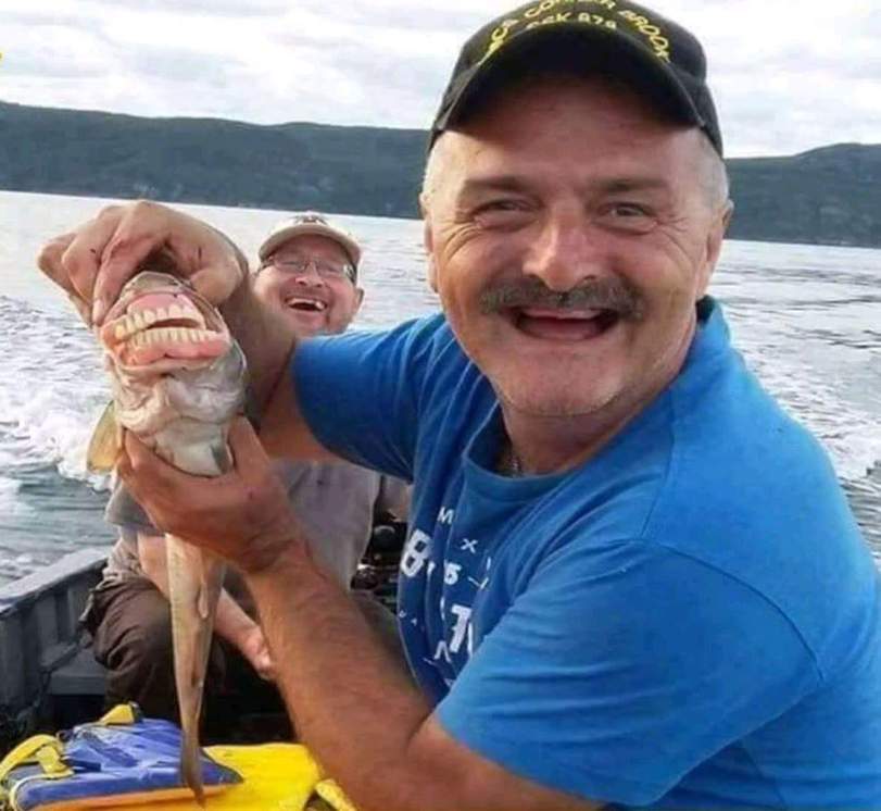 Witziger Angler freut sich über Fisch - Fisch mit Zähnen